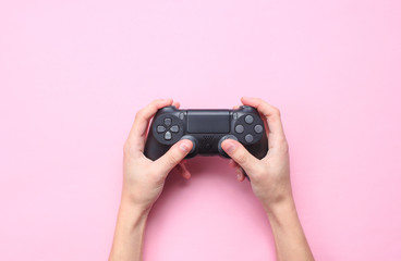 Sticker - Hands to use the gamepad on pink background. Top view, minimalism .