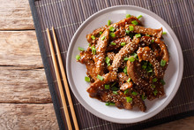 Traditional Asian Beef Teriyaki With Green Onions And Sesame Close-up On A Plate. Horizontal Top View