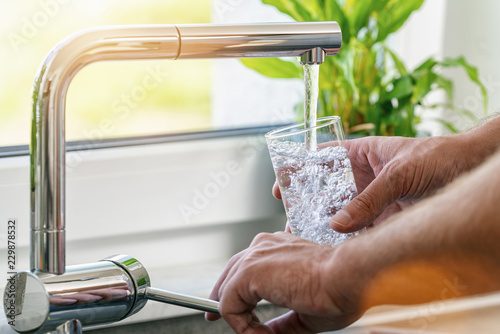 Cuadros en Lienzo Filling glass of water from stainless steel kitchen faucet