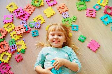 Wall Mural - little girl playing with puzzle, early education