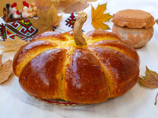 Homemade pumpkin shaped bread located on a white background. Pumpkin shape