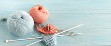 Knitting Wool And Knitting Needles In Pastel Blue And Pink Colors On Blue  Wooden Background. Top View.copy Space.banner