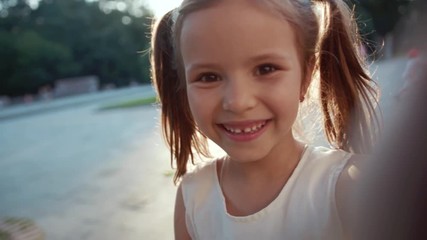 face of pretty caucasian little lady with wonderful smile. beautiful ukrainian child holding smartph