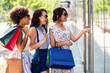© Syda Productions - sale, consumerism and people concept - happy young women with shopping bags pointing finger to shop window in city