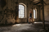Fototapeta Na drzwi - Athletic woman doing kettlebell swing in an old building