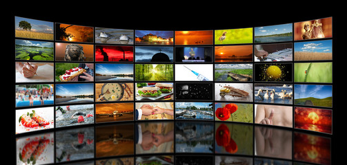 Wall of stacked TV screens with various motifs on a black background