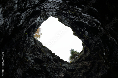 Fotomural View of the sky and trees from the bottom of a stone mine