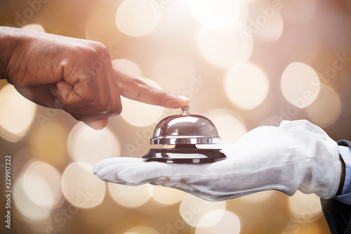 Cuadros en Lienzo Customer Ringing Service Bell Held By Butler