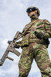 military man holding automatic rifle and hand grenade