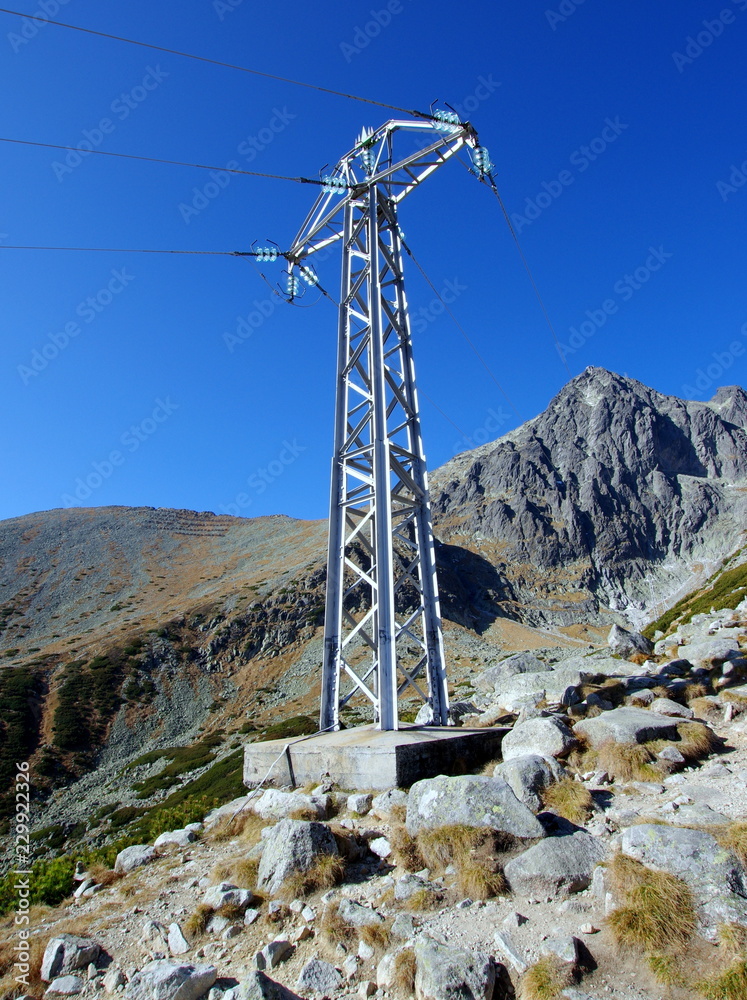 Konstrukcja wsporcza do prowadzenia przewodów linii napowietrznych, słup elektroenergetyczny w wysokich górach, Wysokich Tatrach na Słowacji  - obrazy, fototapety, plakaty 