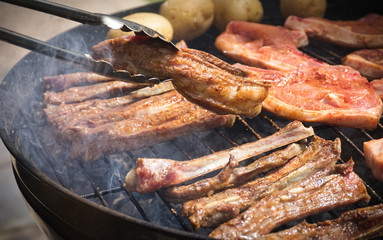 turning tasty spiced meat being cooked on a braai or barbeque