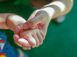 parenting and little baby hand holding tight together for love and care concept