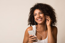 Smiling African-american Woman In Earbuds Listening Music