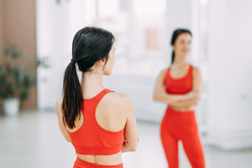 Portrait of a beautiful girl in the gym. Yoga style and instructor with Mat.