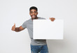 © Prostock-studio - African-american man holding white blank board and showing thumb up