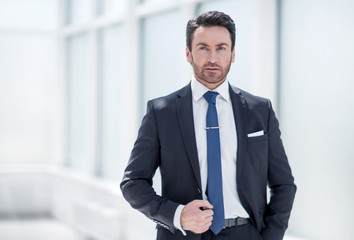 serious businessman standing near an office window