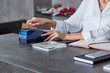 © LIGHTFIELD STUDIOS - Cropped shot of young female seller holding credit card and using payment terminal in shop