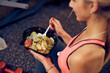 Leinwandbild Motiv Top view of woman eating healthy food while sitting in a gym. Heatlhy lifestyle concept.