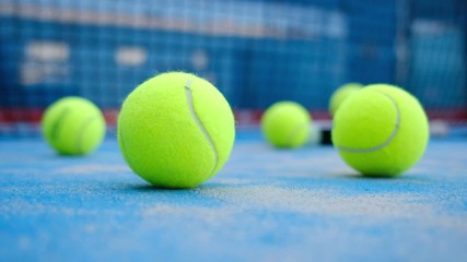 Paddle tennis objects on turf. A player come later and take racket and ball