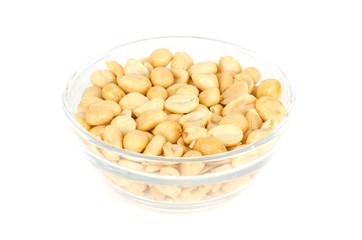 Wall Mural - Roasted and salted peanuts in glass bowl. Shelled Arachis hypogaea, also called groundnut or goober, used as a snack. Isolated macro food photo, close up, from above, on white background.