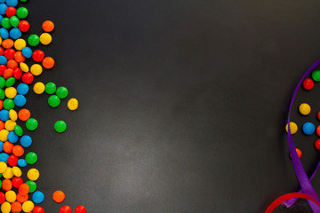  colorful chocolate buttons on a black background