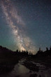 © Stocksy - The milky way rising above an alpine landscape with its light reflecting in a creek