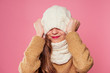 © yurakrasil - Beautiful little girl in winter warm colorful hat and scarf dreaming thought about the gift Christmas night in the studio on a pink background.portrait photography child model