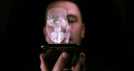 Wall Mural - Male holding up smart phone with a hologram of his 3D face projecting out of the screen