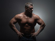 © Vladimir - Powerful muscular bodybuilder posing on a black background. concept of strength and health