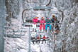 family skier and snowboarder lifting on the chairlift at ski resort