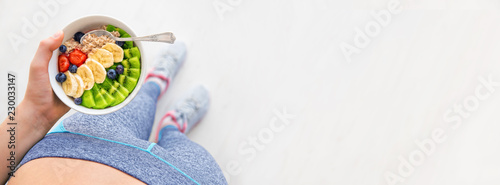 Cuadros en Lienzo Young woman is resting and eating a healthy oatmeal after a workout