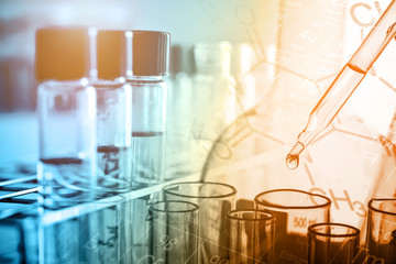 Wall Mural - dropping chemical liquid to test tube with lab glassware background. science or chemistry research a