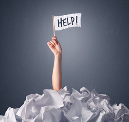 Wall Mural - Female hand emerging from crumpled paper pile holding a white flag with help written on it