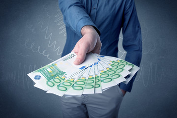 Wall Mural - Young businessman holding large amount of bills with grungy background