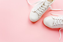 White Female Sneakers On Pink Background. Flat Lay, Top View Minimal Background. Fashion Blog Or Magazine Concept.