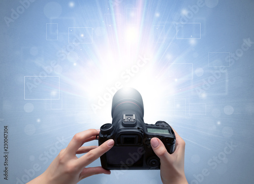 Fotografía Naked hand taking picture with digital camera and glowing flash concept