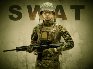 Uniformed armed soldier with damaged wall background
