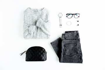 Women fashion clothes and accessories. Feminine youth collage on white background top view. Flat lay female style look with warm sweater, jeans, glasses. Top view.