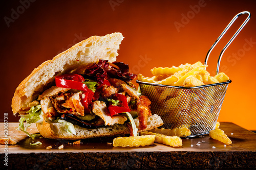 Fototapeta na szkło Kebab - grillowane mięso z frytkami i warzywami na drewnianym tle