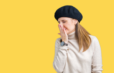 Wall Mural - Middle age mature woman wearing winter sweater and beret over isolated background bored yawning tired covering mouth with hand. Restless and sleepiness.