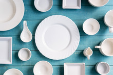 Various Empty White Plates And Bowls On Wooden Background, Top View
