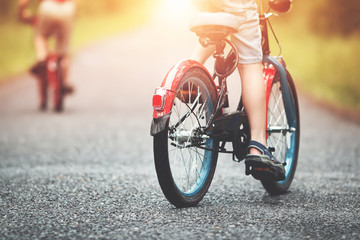 children on a bicycle at asphalt road in early morning