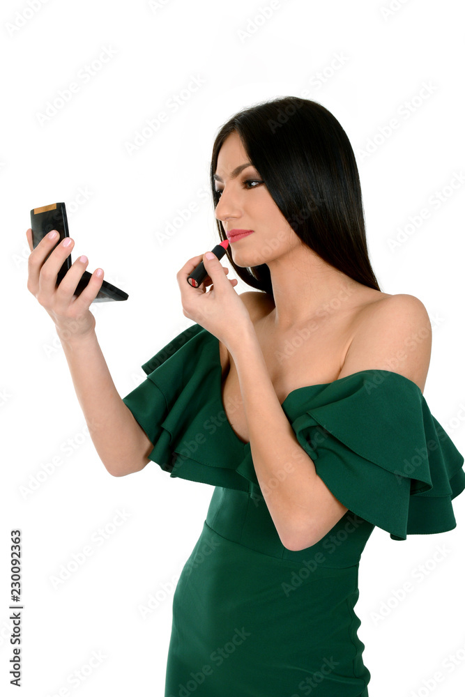 Young woman in green dress holding mirror, applying red lipstick Stock  Photo | Adobe Stock