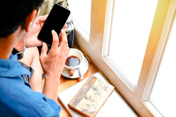 Wall Mural - Cropped short view of man hands holding smartphone with blank copy space screen for your text message or information content,  reading text message on cell telephone during in urban setting.