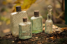 Four Vintage Perfume Bottles On The Stump