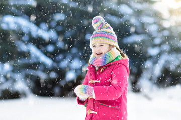 Wall Mural - Child playing with snow in winter. Kids outdoors.