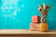 Christmas Holiday Concept With  Pineapple As Alternative Christmas Tree And Gift Boxes On Wooden Table With Copy Space