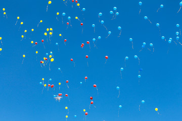 Bright blue, red and yellow air balloons  rise up in the blue sky. Balls background, aerostat.