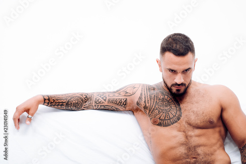 Fotografía Nude male model lies in white bed