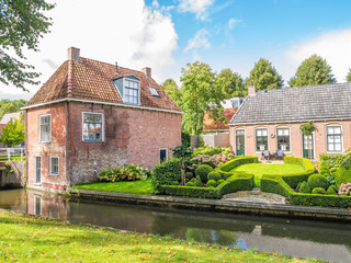 Wall Mural - Streetscene of canal with waterfront houses and gardens in old town of Dokkum, Friesland, Netherlands